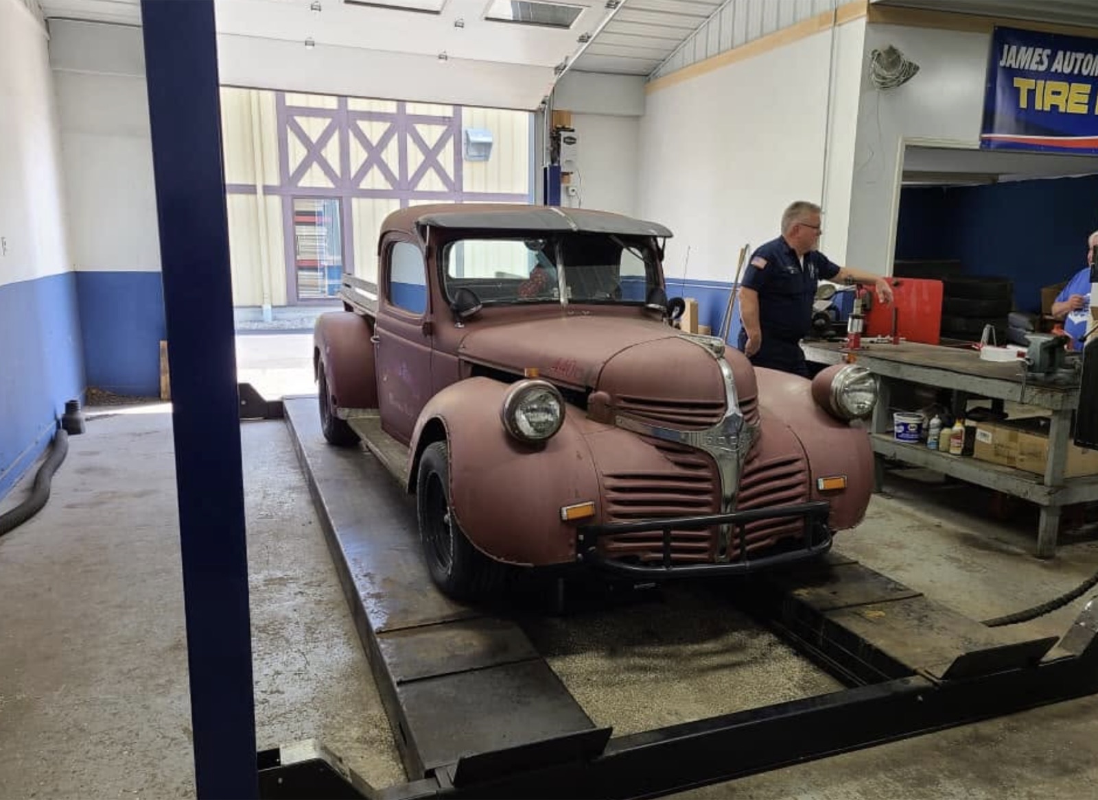 Vehicle on a lift inside James Automotive Repair's service bay in Churubusco